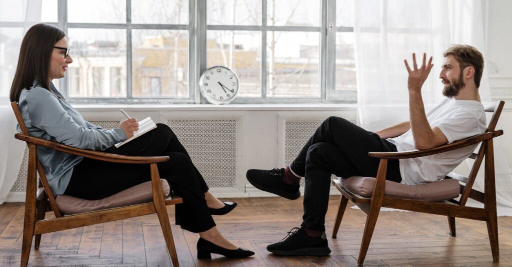 A therapist engaging in a counseling session with a male patient to support mental health.