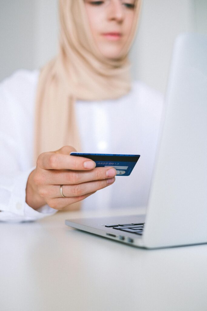 A woman using a laptop and credit card for an online shopping transaction.