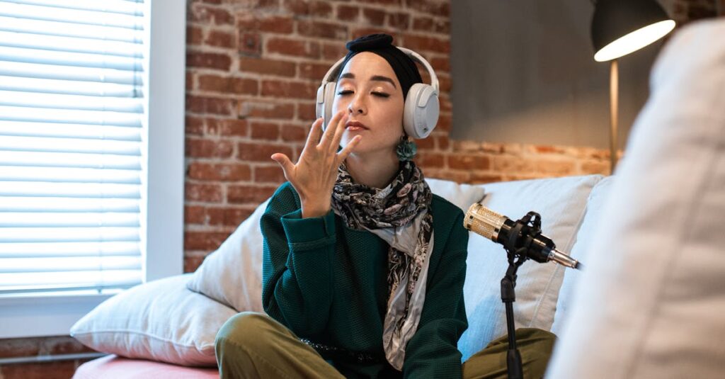 A young woman podcasting with microphone and headphones in a cozy home setup.