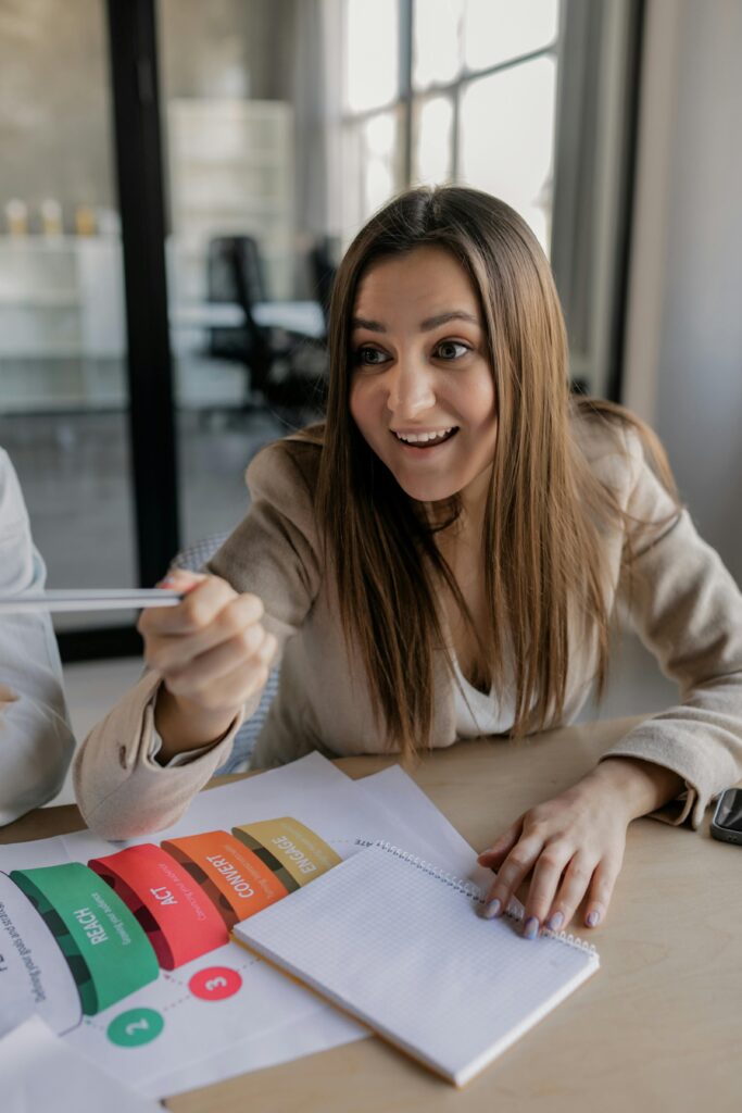 Young woman excitedly discussing ideas in a modern office setting.